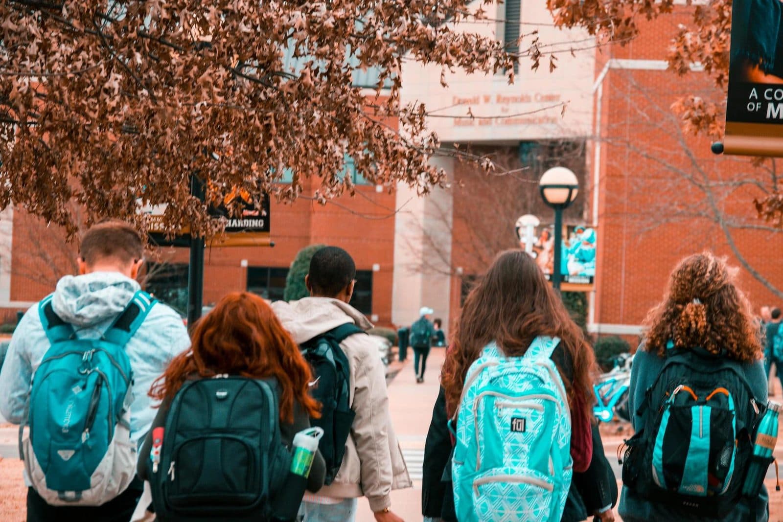Students with backpacks walking across a university campus