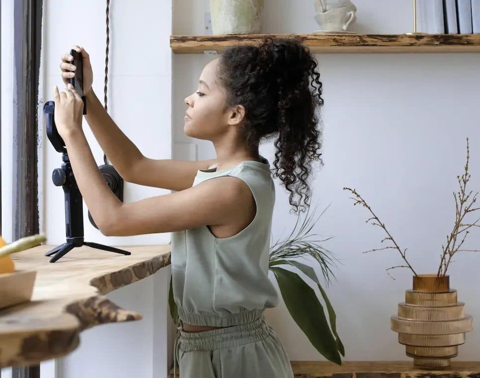Creator filming herself on a phone tripod at home