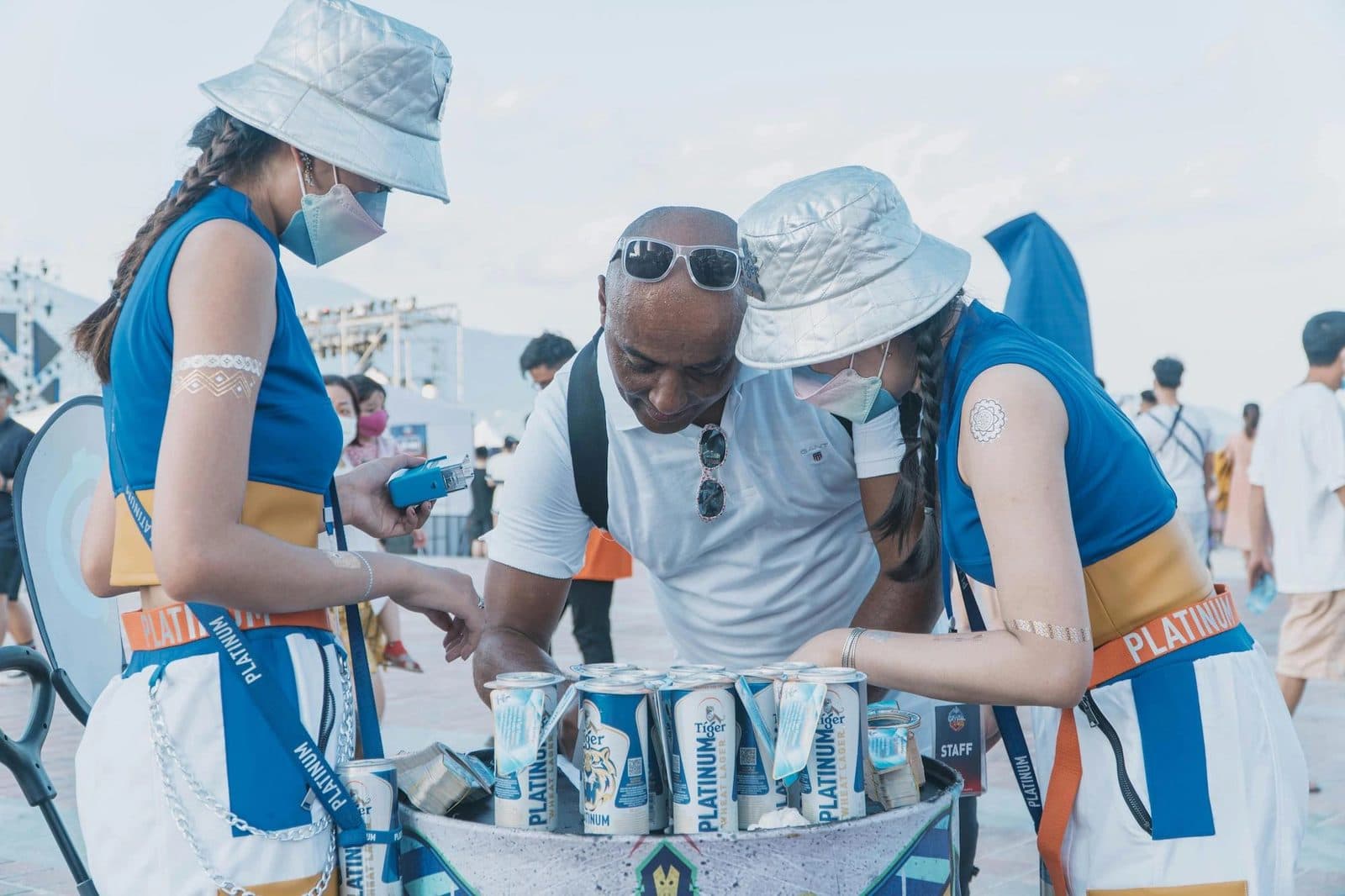 Promo staff in branded outfits handing out drinks samples at an outdoor event